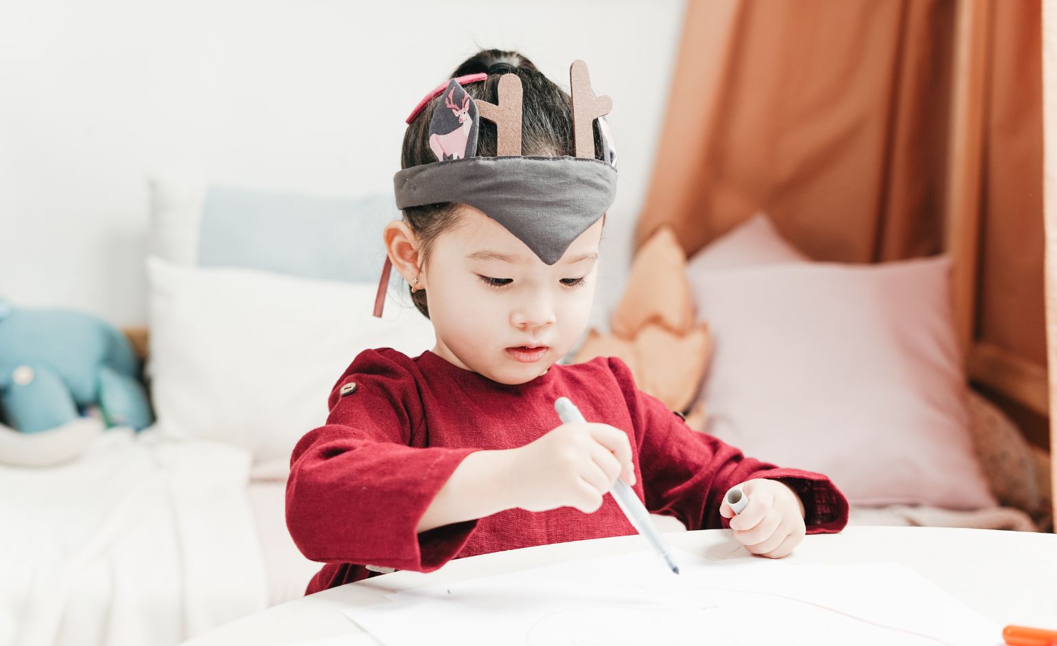 Child wearing DIY crown and holding a marker